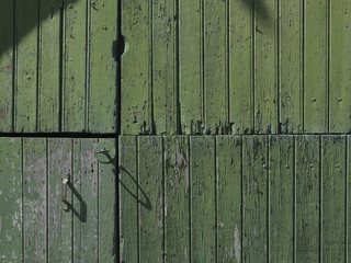 part of old worn down grungy green painted barn door with vertical planks