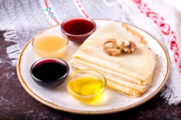 A  stack of pancakes with sauces