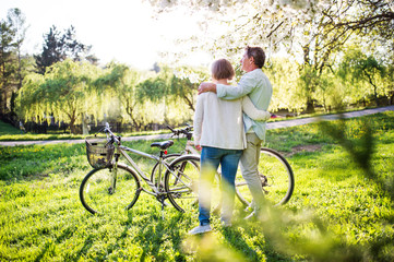Obraz premium Beautiful senior couple with bicycles outside in spring nature.