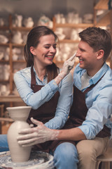 Smiling couple at the potter's wheel