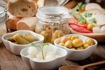 Tapas with sliced sausage, salami, olives and parsley.