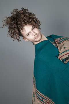 Young athletic ginger man in pancho studio portrait