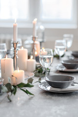 Fototapeta na wymiar Wedding or festive table setting. Plates, wine glasses, candles and cutlery