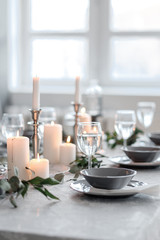 Fototapeta premium Wedding or festive table setting. Plates, wine glasses, candles and cutlery
