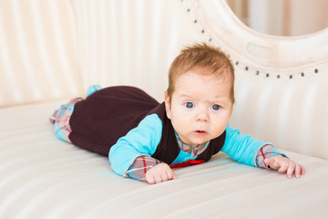 Fototapeta premium Adorable baby boy in sunny bedroom. Newborn child relaxing