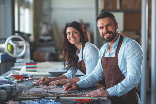 Smiling people with a mosaic in workshop