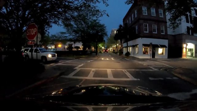 CHARLESTON, SC - APRIL 7, 2018: City traffic at night, view from the car bonnet. The city attracts 15 million people annually