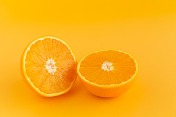 Glass of orange juice freshly squeezed on an orange background