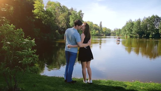 Slow motion footage of beautiful young couple kissing by the river at forest