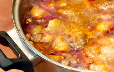 Masaman curry chicken cooking with the pot is boiling and smoked in the kitchen