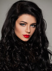 Brunette Woman Face. Elegant Female Model with Curly Hairstyle and Makeup