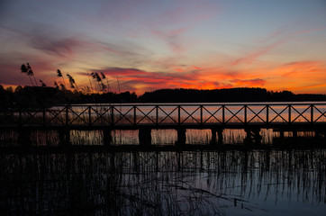 Fototapeta na wymiar Wooden bridge on a lake at sunset. masuria, Poland