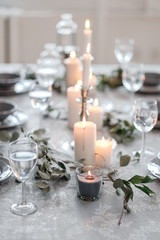 Fototapeta na wymiar Wedding or festive table setting. Plates, wine glasses, candles and cutlery