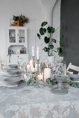 Wedding or festive table setting. Plates, wine glasses, candles and cutlery