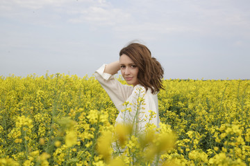 Naklejka na ściany i meble Portrait of fashionable young woman in the yellow flowers field 