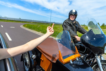 Fototapeta na wymiar a car driver shows his middle finger to a biker