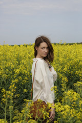Fototapeta premium Portrait of fashionable young woman in the yellow flowers field 