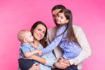 Fototapeta premium Portrait of Young Happy Mixed Race Family over pink background.