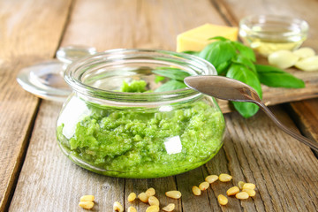 Homemade pesto sauce. Ingredients. Cheese, garlic, basil, pine nuts, olive oil on an old wooden table.