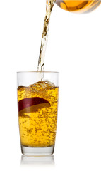 Apple juice flowing from transparent jug into glass with an appl