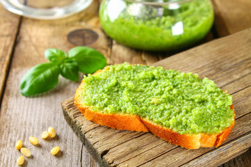 Homemade pesto sauce, bread. Ingredients. Cheese, garlic, basil, pine nuts, olive oil on an old wooden table.