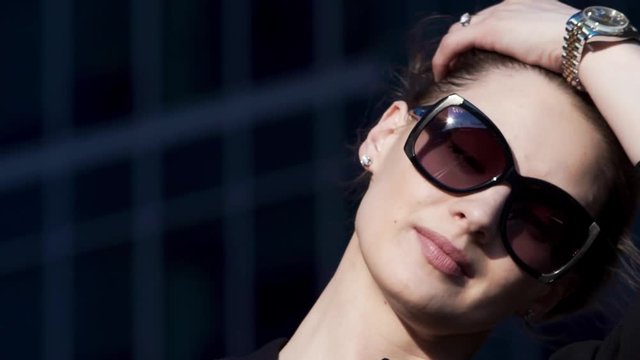 Close-up portrait attractive young walking business woman in sunglasses