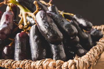 Close up of Black seedless moon drops grape or Witch fingers grape in basket