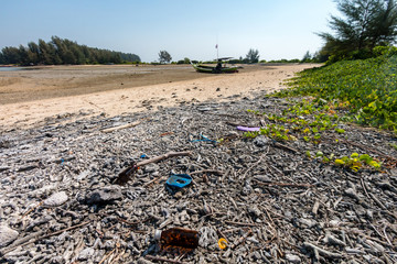 Obraz premium Discarded plastic bottles and other trash on a tropical beach in asia