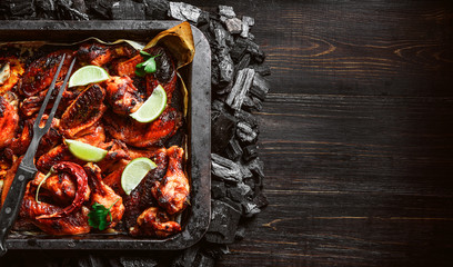 chicken wings of barbecue in honey sauce with lime slices. the dish is made and served in a rustic style