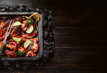 chicken wings of barbecue in honey sauce with lime slices. the dish is made and served in a rustic style