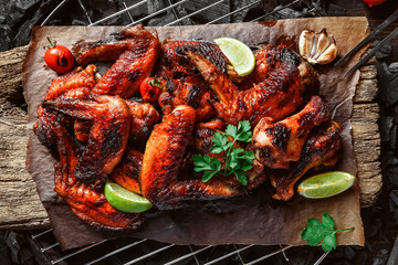 chicken wings of barbecue in honey sauce with lime slices. the dish is made and served in a rustic style