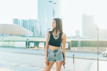 young woman outdoor posing looking away back light - influencer, blogger concept