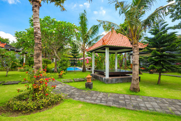 Beautiful tropical garden with swimming pool, palms and flowers