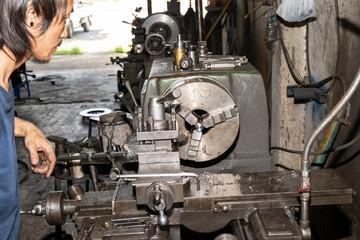 Man working on a lathe not wear protective personal equipment. Not safe for work