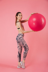 Vertical side view image of mystery sportswoman holding fitness ball