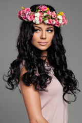 Young Brunette Woman with Curly Hair and Flowers