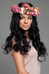 Naklejka premium Young Brunette Woman with Curly Hair and Flowers
