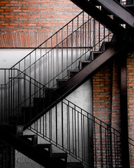 Zigzag pattern metal staircase with brick wall background