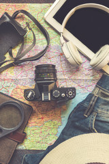 Travel accessories camera, straw hat, card, shoes, laptop, on a dark background flat top view layout with copy space concept life style brutal toned