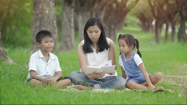 Slow motion, Happy family, Mother daughter and son joint a activities by read book in garden.