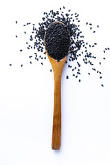 Spoon full of balck sesame grains on white background