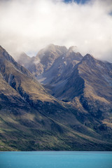 Jagged peaks appearing through mist.  Lake Wakatipu, New Zealand
