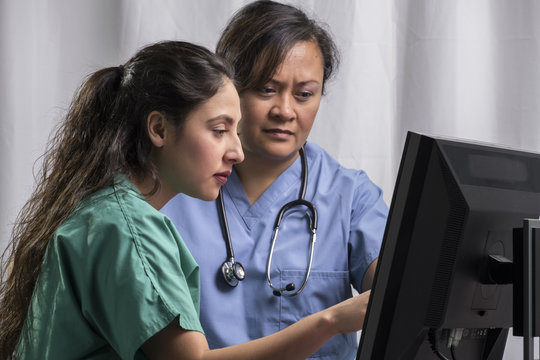 Medical team reading computer screen together