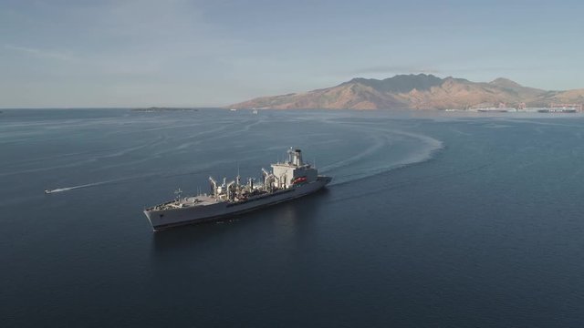 Aerial view: Cargo, Reefer ship in the sea bay. Subic Bay, Philippines, Luzon. Cargo ship in the harbor, against the backdrop of the mountains.
