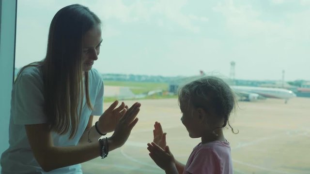 Yound mother and little cute daughter having fun at airport.