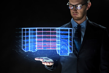 architecture, technology and construction concept - close up of businessman with virtual building blueprint projection