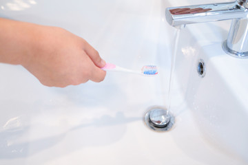 Hands holding toothbrush with bleeding per gum concept.