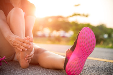 Ankle sprained. Young woman suffering from an ankle injury while exercising and running. Healthcare and sport concept.