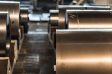 Fototapeta na wymiar Stock with rolls of sheet steel in industrial plant