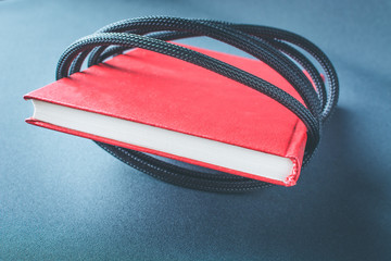 Red book wrapped in black wire